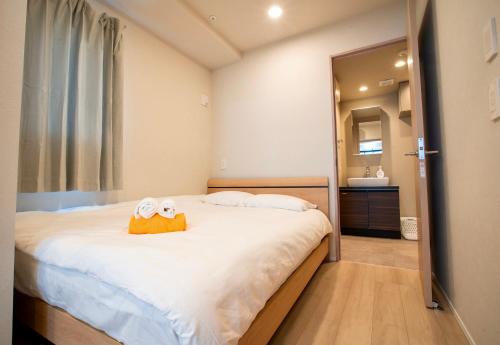 a bedroom with a bed with two towels on it at Uhome Fabric Hotel in Tokyo