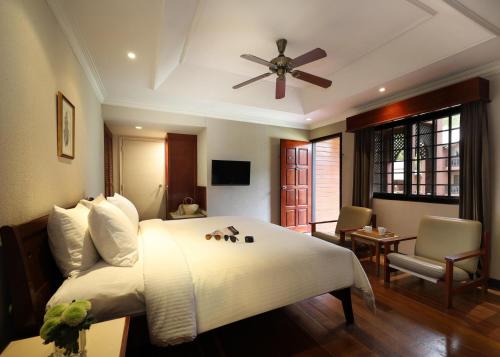 a bedroom with a large bed with a ceiling fan at Berjaya Tioman Resort in Tioman Island