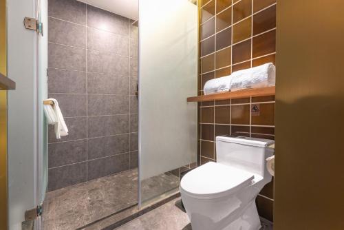 a bathroom with a white toilet and a shower at Atour X Hotel Beijing Daxing Airport Wildlife Park in Daxing