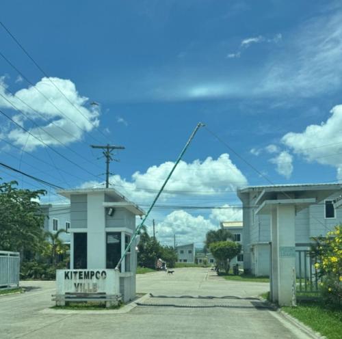 a building with a tower in a parking lot at The Bocol's House Stay in Sampong