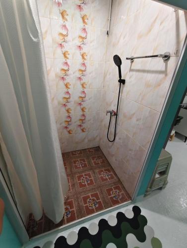 a shower with a shower curtain and a shower head at AuraHome282 in Khlong Luang