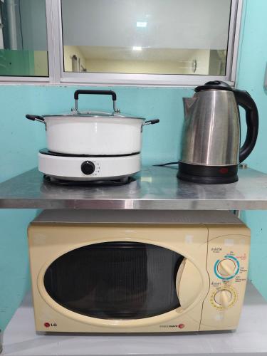 a slow cooker sitting on top of a microwave at AuraHome282 in Khlong Luang
