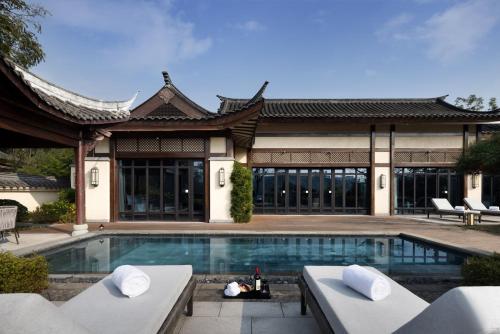 a villa with a swimming pool in front of a house at Song Hotel Chengdu Qingcheng in Dujiangyan