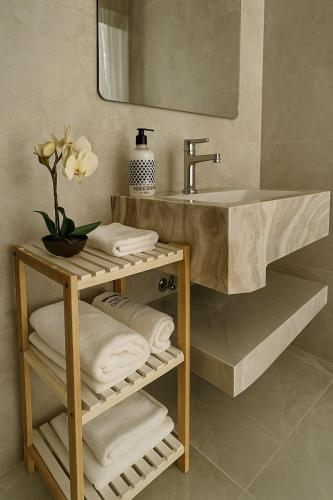 a bathroom with a sink and a shelf with towels at شقه غرفتين وصاله بشرفه in Al-ʿUla