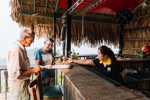 a group of three people standing around a bar at TVpalm Ecolodge in Ha Giang