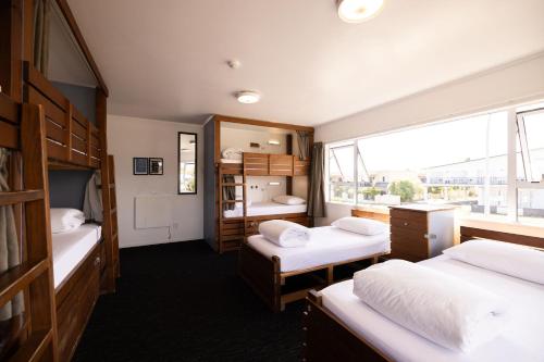 a small room with two beds and a window at Haka House Taupo in Taupo