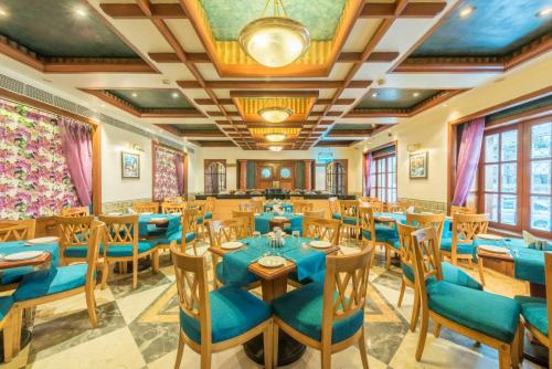 una sala da pranzo con tavoli e sedie blu di Hotel Parle International a Mumbai