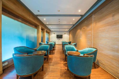 a row of blue chairs in a waiting room at Hotel Parle International in Mumbai