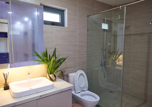 a bathroom with a shower and a toilet and a sink at Mica's House in Cồn Giả Viên