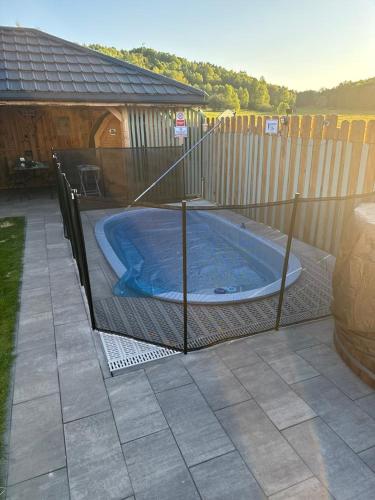 a fence around a hot tub in a backyard at Sielski Zaułek Guciów u Dorotki -Basen,Jacuzzi,Sauna in Guciów