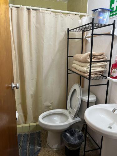 a bathroom with a toilet and a shower curtain at Cómodo departamento en el corazón de Cancún in Cancún