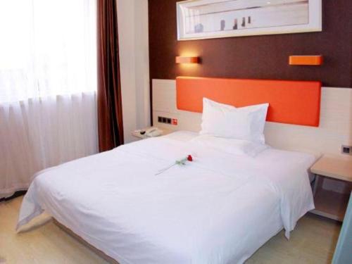 a large white bed in a hotel room at 7 Days Premium Beijing Dabaotai Metro Station Luhua Road in Beijing
