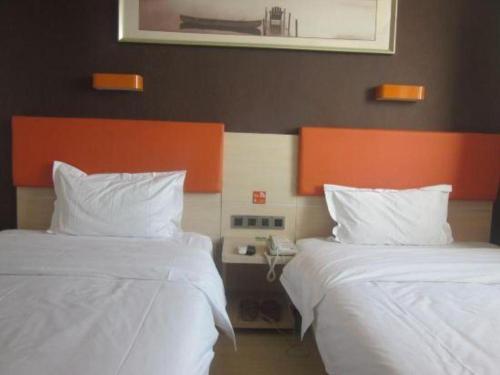 two beds sitting next to each other in a bedroom at 7 Days Premium Beijing Dabaotai Metro Station Luhua Road in Beijing