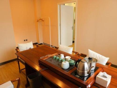 a dining room table with a tea kettle on it at 7 Days Premium Beijing Dabaotai Metro Station Luhua Road in Beijing