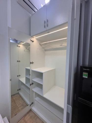 a white walk in closet with white shelves at Nemaru urban stay in Ho Chi Minh City