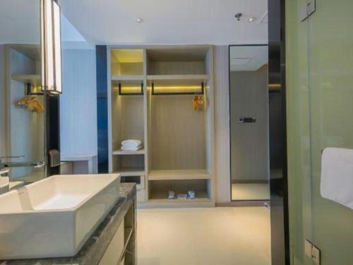 ein Badezimmer mit Waschbecken und Dusche in der Unterkunft Echarm Hotel Xinyu Railway Station Baoshi Park in Xinyu