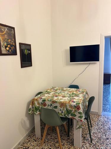 una sala da pranzo con un tavolo e una TV a parete di Domus Olea & Opuntia Salento a Galatone