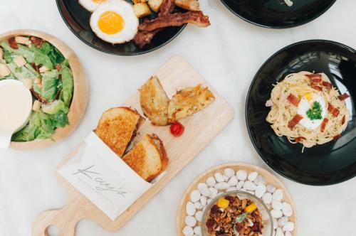 a table full of plates of food with eggs and toast at K Maison Boutique Hotel in Bangkok