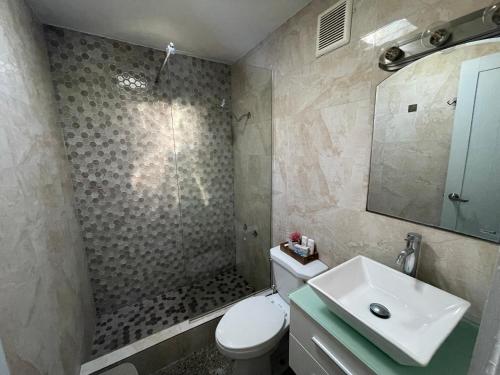 a bathroom with a toilet and a sink and a mirror at “Lucor D-Eight House” New Entire Home in the Town… in Rincon