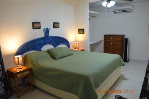 a bedroom with a large bed with a blue headboard at Oasis del Mar- Departamento Palma in Progreso