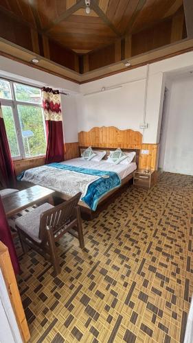 a bedroom with a large bed and a wooden ceiling at Deepak Homestay in Kalpa
