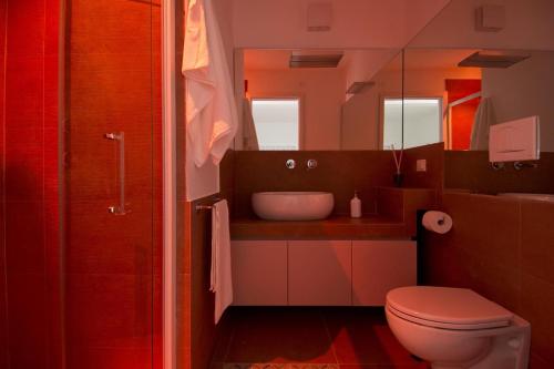 een badkamer met een toilet, een wastafel en een spiegel bij Casa Perugini in Monopoli
