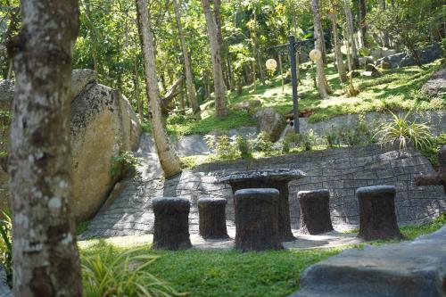 a garden with a stone table and some trees at Rock Garden Villa Pinnawala in Rambukkana
