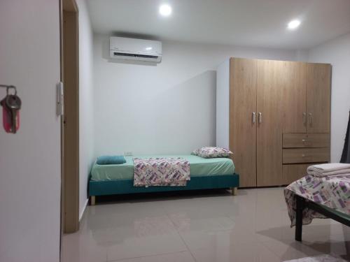 a bedroom with a bed and a wooden cabinet at Casa Bacoba in Santa Marta