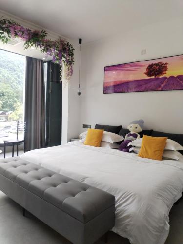 a bedroom with a large white bed with yellow pillows at Fantasy Homestay in Yangshuo