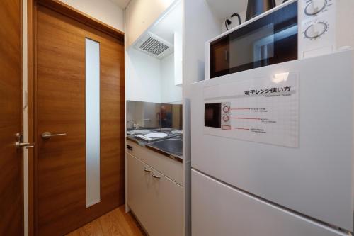 a kitchen with a sink and a microwave at Zenith Garden TOGOSHI in Tokyo