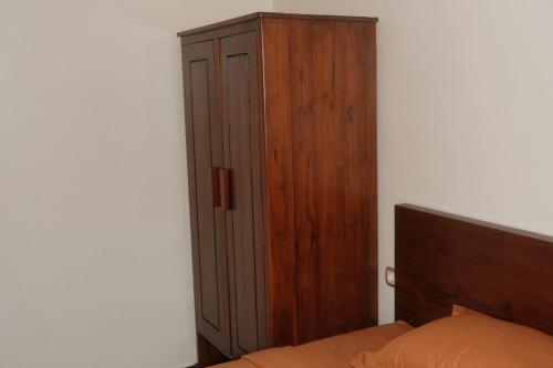 a bedroom with a wooden cabinet next to a bed at Ntala in Komodo Labuan Bajo Airport