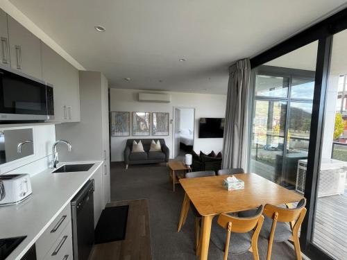 a kitchen and living room with a table and a couch at Your Queenstown adventure base! in Queenstown