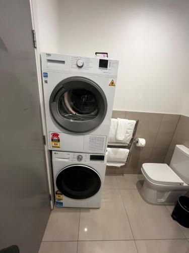 a washing machine in a bathroom with a toilet at Your Queenstown adventure base! in Queenstown