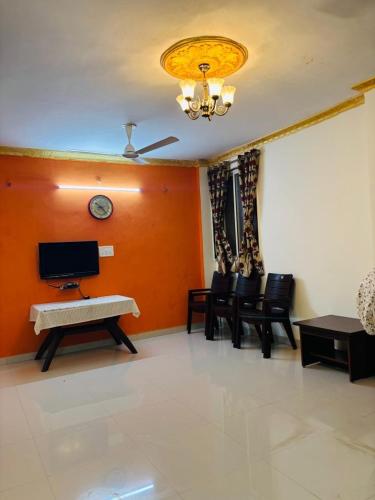 a living room with a table and chairs and a clock at Samartha Krupa Homestay in Wai
