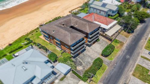 an aerial view of a house next to the beach at Manyana Accom Holidays in Wamberal