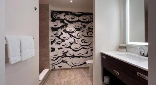 a bathroom with a toilet and a wall with clouds at Ahern Hotel and Event Center in Las Vegas