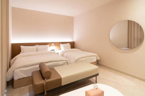 a hotel room with two beds and a mirror at Goyang Hotel Yuji in Goyang