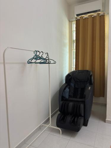 a black chair in a room with a glass stand at KM Homestay in Merlimau