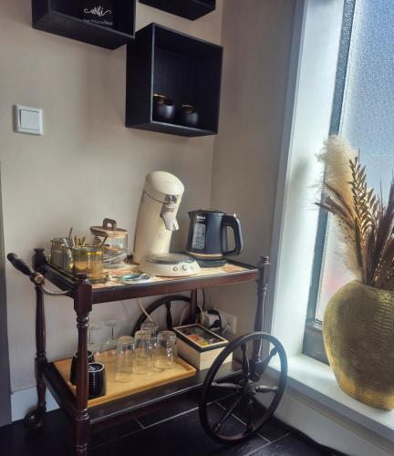 a shelf with a coffee maker on it next to a window at Ons kleine huisje in Gasselte