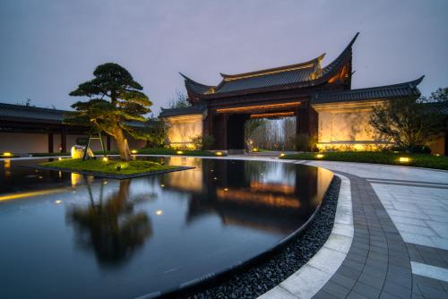 a building with a pond in front of a building at Song Hotel Chengdu Qingcheng in Dujiangyan