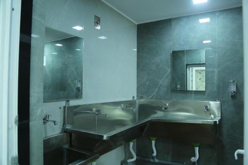 a bathroom with two sinks and a large mirror at Akshayaa Grand in Visakhapatnam