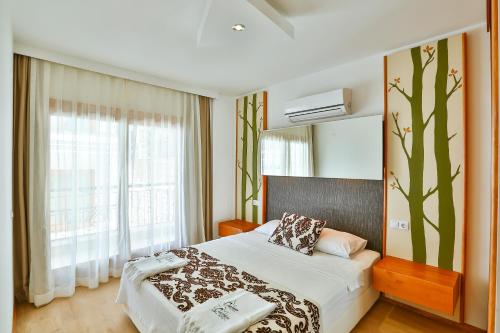 a bedroom with a bed and a large window at Çınarlar Apart Hotel KAŞ in Kas