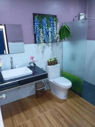 a bathroom with a toilet and a sink and a mirror at 9 Home Phuket in Ban Rangeng