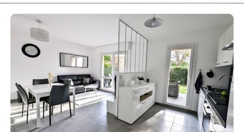 - une cuisine blanche et une salle à manger avec une table et des chaises dans l'établissement Apt with garden in Ferney Ideal UN or CERN, à Ornex