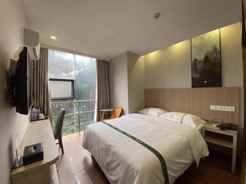 a hotel room with a bed and a window at GreenTree Inn Shenzhen Guanggang Port Futian South Road Express Hotel in Hong Kong