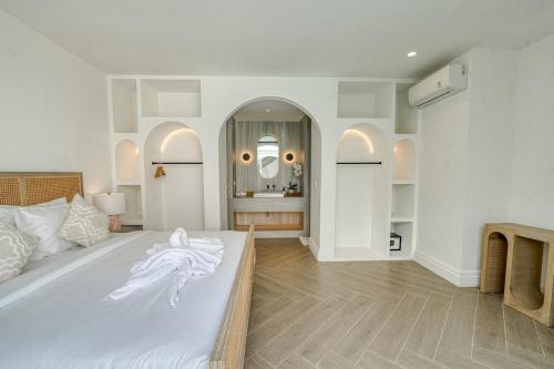 a bedroom with a large white bed and a bathroom at Cemagi Suites Brand New 3BR Villas in Cemagi