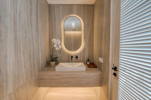 a bathroom with a white sink and a mirror at Cemagi Suites Brand New 3BR Villas in Cemagi