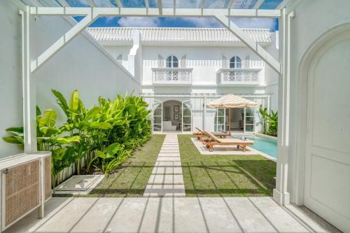 a white house with a patio and a pool at Cemagi Suites Brand New 3BR Villas in Cemagi