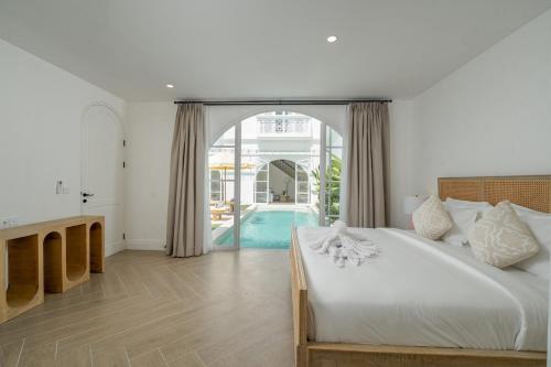 a bedroom with a large bed and a pool at Cemagi Suites Brand New 3BR Villas in Cemagi