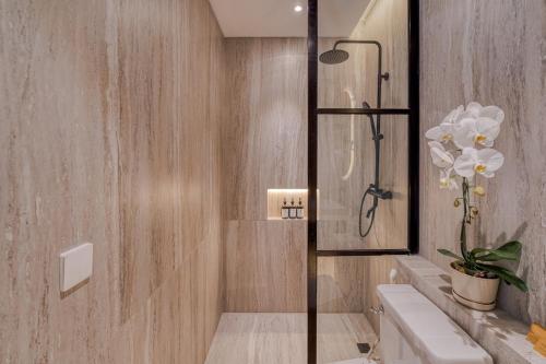 a bathroom with a shower with a toilet and a sink at Cemagi Suites Brand New 3BR Villas in Cemagi